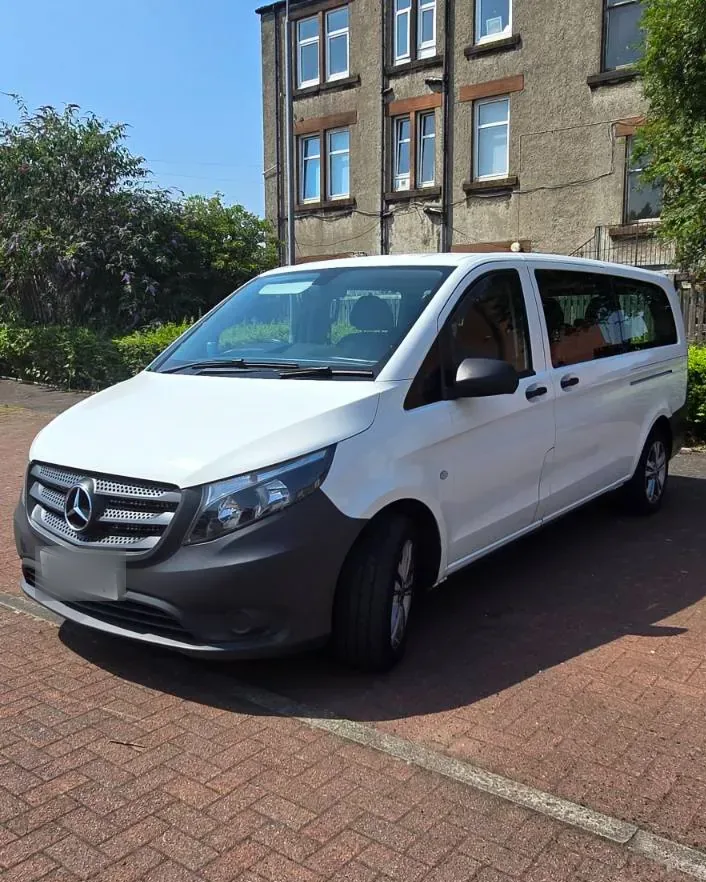 Side view of the long-wheelbase 8-seater van showing the wide sliding passenger door